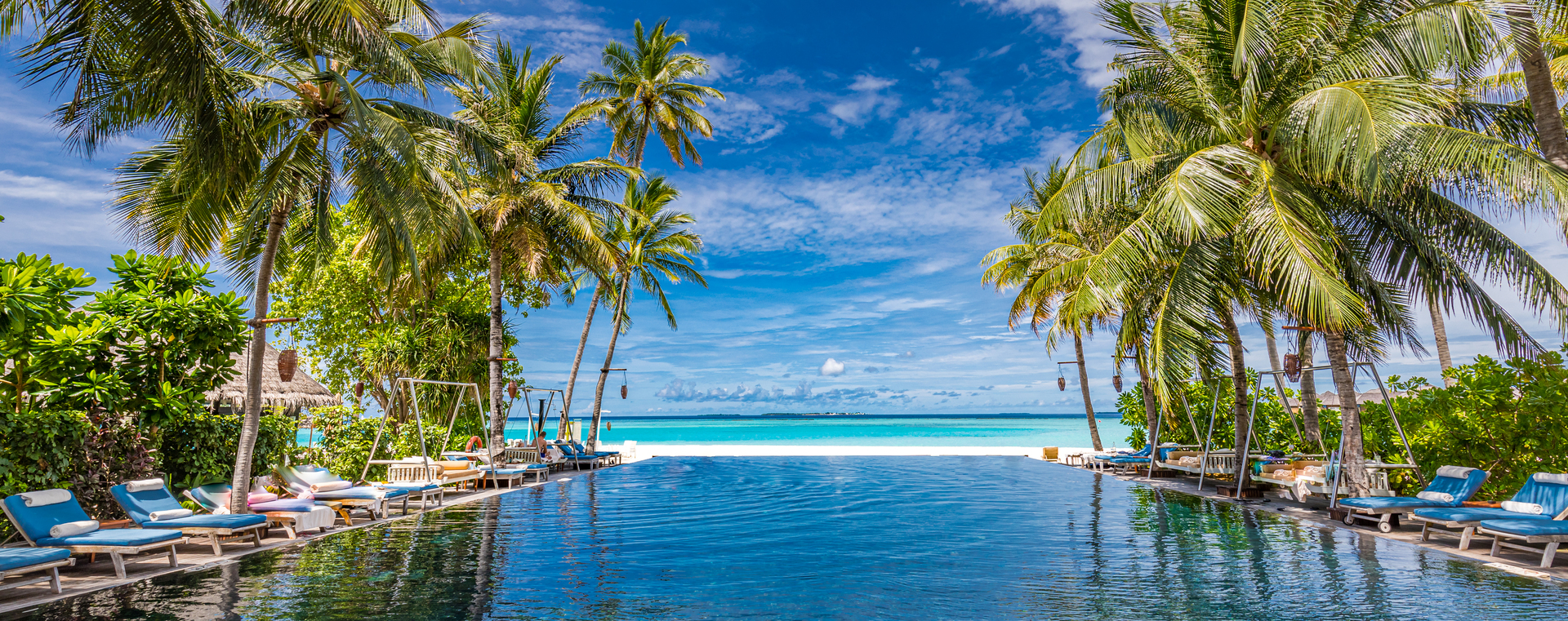 A luxury resort pool with an uninterrupted sea view